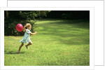 1980s Little Girl With A Red Balloon Running In The Grass by Anonymous