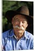 1990s Portrait Of Smiling Cowboy With Gray Mustache Black Hat Blue Shirt Looking At Camera by Corbis