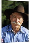 1990s Portrait Of Smiling Cowboy With Gray Mustache Black Hat Blue Shirt Looking At Camera by Corbis