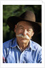 1990s Portrait Of Smiling Cowboy With Gray Mustache Black Hat Blue Shirt Looking At Camera by Corbis