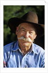 1990s Portrait Of Smiling Cowboy With Gray Mustache Black Hat Blue Shirt Looking At Camera by Corbis