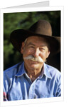 1990s Portrait Of Smiling Cowboy With Gray Mustache Black Hat Blue Shirt Looking At Camera by Corbis