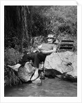1950s Lazy Fisherman Lying Back On Rock With Hat Pulled Over Eyes Fishing In Creek by Anonymous