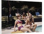 1960s Four People On Patio Couple Man Woman Sitting On Edge Of Swimming Pool by Anonymous