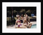 1960s Four People On Patio Couple Man Woman Sitting On Edge Of Swimming Pool by Anonymous