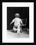 1930s Baby Wearing Drop Seat Pajamas Showing Bare Bottom Leaning On Chair by Anonymous
