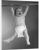 1960s Baby Hanging From Rod With Frightened Expression On Verge Of Tears by Anonymous