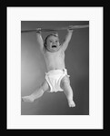 1960s Baby Hanging From Rod With Frightened Expression On Verge Of Tears by Anonymous