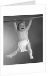 1960s Baby Hanging From Rod With Frightened Expression On Verge Of Tears by Anonymous
