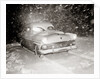 1950s Snow Covered Automobile Driving On Road In Deepening Winter Blizzard Snow by Anonymous
