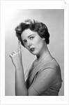 1950s Concerned Woman With Reminder String Knot Tied On Finger Of Hand To Help Remember Something Looking At Camera by Anonymous