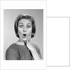1960s Portrait Woman With Hand On Cheek Looking At Camera With Shocked Expression by Anonymous