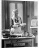 1920s 1930s Senior Woman Grandmother Wearing Apron Crimping Crust Making A Cherry Pie In Kitchen by Anonymous