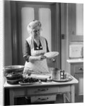 1920s 1930s Senior Woman Grandmother Wearing Apron Crimping Crust Making A Cherry Pie In Kitchen by Anonymous