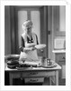 1920s 1930s Senior Woman Grandmother Wearing Apron Crimping Crust Making A Cherry Pie In Kitchen by Anonymous