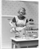 1930s Woman In Kitchen Wearing Apron Making Breakfast Pouring Water Into Coffee Pot by Anonymous