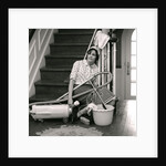 1960s 1970s Exhausted Housewife Sitting At Bottom Of Stairs Surrounded By House Cleaning Equipment by Anonymous