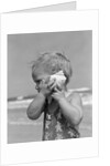 1950s Blond Toddler Girl Listening To Ocean In A Seashell Wearing Teddy Bear Bathing Suit by Anonymous