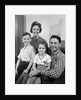 1960s Family Sitting On Couch Smiling Looking At Camera by Anonymous
