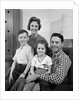 1960s Family Sitting On Couch Smiling Looking At Camera by Anonymous