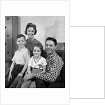 1960s Family Sitting On Couch Smiling Looking At Camera by Anonymous