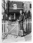 1940s Smiling Pretty Young Teenage Girl Standing By White Picket Fence In Front Of Stone House In Autumn Looking At Camera by Anonymous