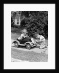 1940s 1930s Boy On Sidewalk Fixing Headlight Of Toy Car Driven By Little Girl Playing Outdoor by Anonymous