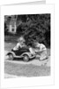 1940s 1930s Boy On Sidewalk Fixing Headlight Of Toy Car Driven By Little Girl Playing Outdoor by Anonymous