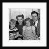 1940s 1950s Portrait Of Smiling Family Man Woman Boy Girl Sitting On Sofa Looking At Camera by Anonymous