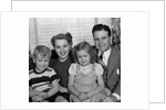 1940s 1950s Portrait Of Smiling Family Man Woman Boy Girl Sitting On Sofa Looking At Camera by Anonymous