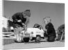 1950s Boy And Girl Playing At Repairing Toy Car by Anonymous