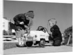 1950s Boy And Girl Playing At Repairing Toy Car by Anonymous