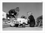 1950s Boy And Girl Playing At Repairing Toy Car by Anonymous