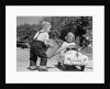 1950s Little Boy Playing Gas Station Pouring Water Into Toy Car For Little Girl by Anonymous