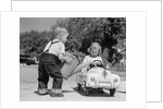 1950s Little Boy Playing Gas Station Pouring Water Into Toy Car For Little Girl by Anonymous