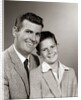 1950s Studio Portrait Smiling Man Father And Boy Son Sitting Together Looking At Camera by Anonymous