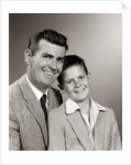 1950s Studio Portrait Smiling Man Father And Boy Son Sitting Together Looking At Camera by Anonymous
