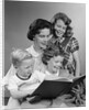 1950s Portrait Mother Two Daughters And Son Reading Book Together by Anonymous