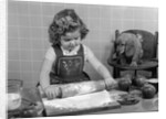 1950s Little Girl Rolling Out Apple Pie Crust On Kitchen Table With Cocker Spaniel Puppy Watching by Anonymous