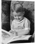 1930s 1940s Little Boy Sitting On Chair Reading Picture Book by Anonymous