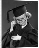 1950s Little Blond Girl Wearing Scholarly Glasses Graduation Cap And Gown Looking At Camera by Anonymous
