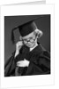 1950s Little Blond Girl Wearing Scholarly Glasses Graduation Cap And Gown Looking At Camera by Anonymous