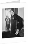 1950s Blonde Mom Opening Front Door To Let In Child Dressed Winter Snow Suit Scarf Hat Can See Snow Scene Through Door by Anonymous