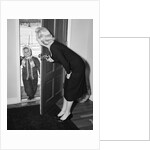 1950s Blonde Mom Opening Front Door To Let In Child Dressed Winter Snow Suit Scarf Hat Can See Snow Scene Through Door by Anonymous