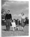 1940s Family Father Mother Son Daughter Holding Hands Together Walking On Grass by Anonymous