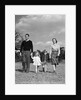1940s Family Father Mother Son Daughter Holding Hands Together Walking On Grass by Anonymous