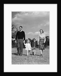 1940s Family Father Mother Son Daughter Holding Hands Together Walking On Grass by Anonymous