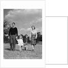1940s Family Father Mother Son Daughter Holding Hands Together Walking On Grass by Anonymous