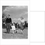 1940s Family Father Mother Son Daughter Holding Hands Together Walking On Grass by Anonymous