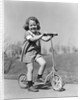 1930s Smiling Girl Playing On Scooter On Sidewalk Looking At Camera by Anonymous
